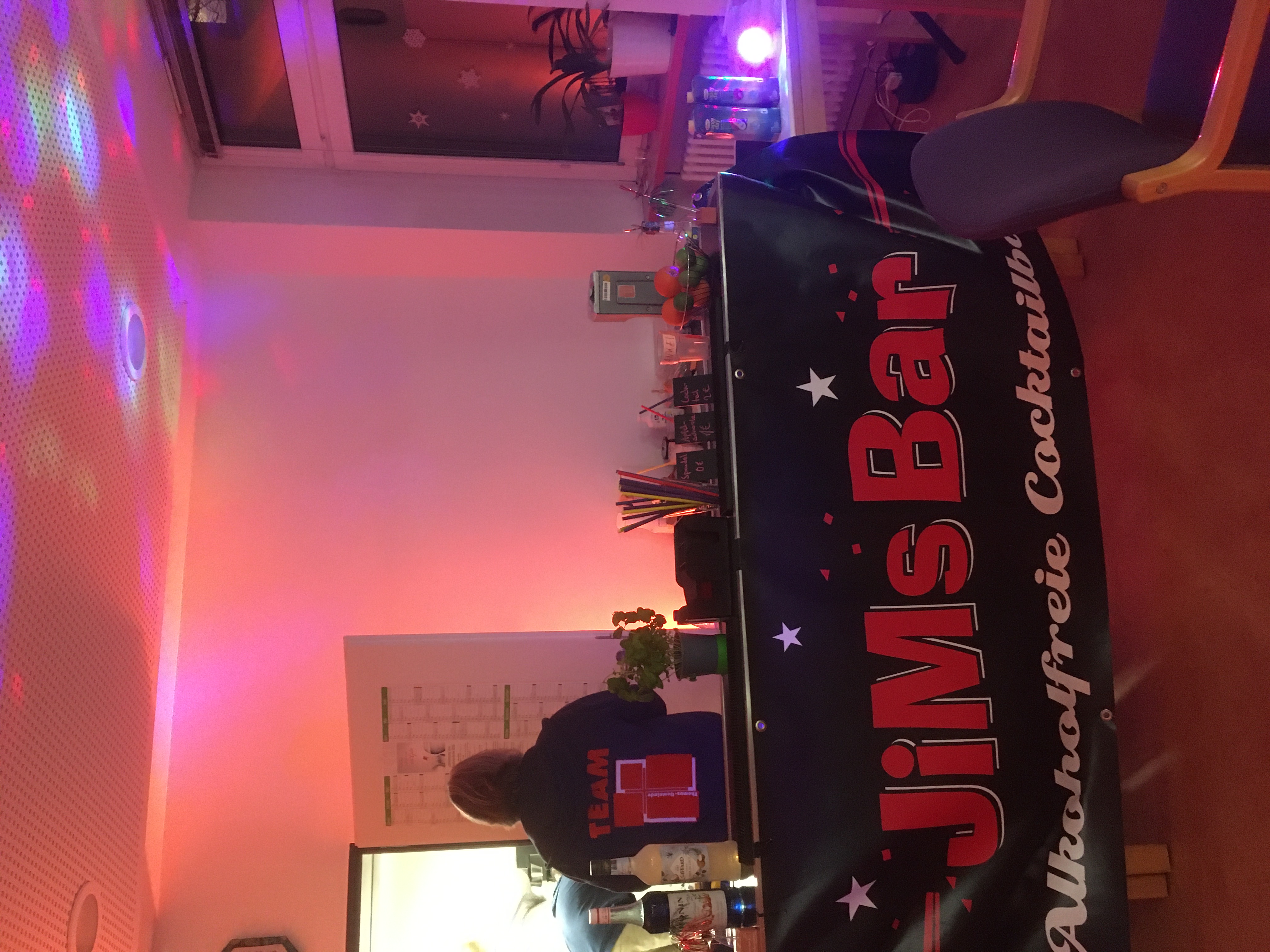 Jim's Bar mit Barkeeper im Team-Shirt.