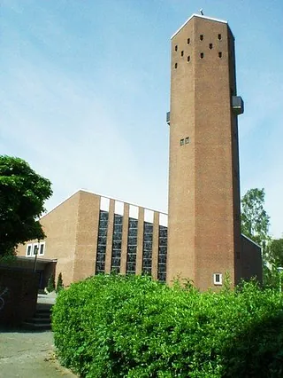 Moderne Kirche mit hohem Turm.