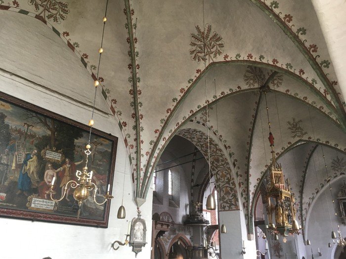 Bemalte Gewölbedecke einer Kirche.
