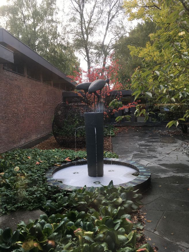 Vogel-Skulpturbrunnen in einem Garten.