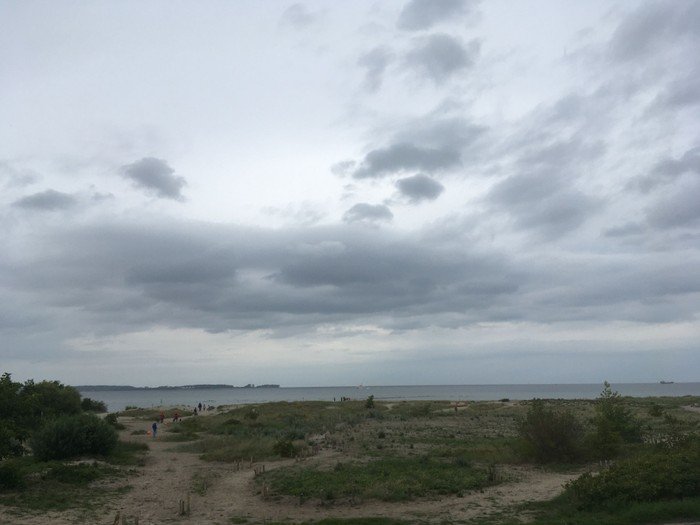 Bewölkter Himmel über Strand und Meer.