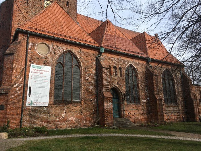 Große Backsteinkirche mit roten Dächern.
