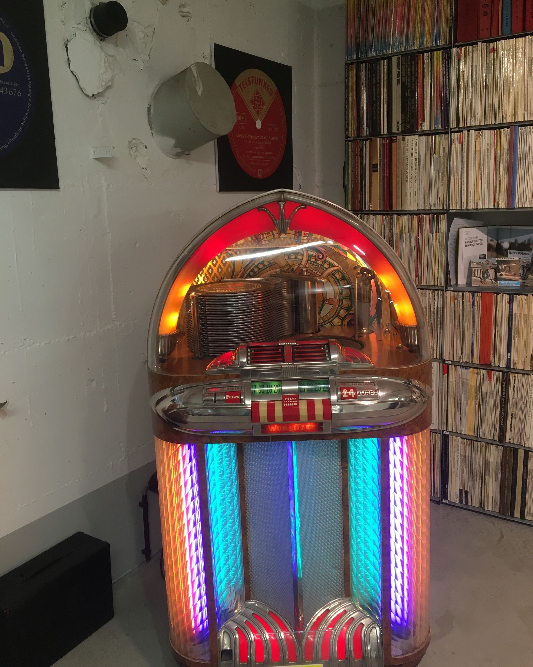 Leuchtende Jukebox in einem Raum mit Schallplatten.