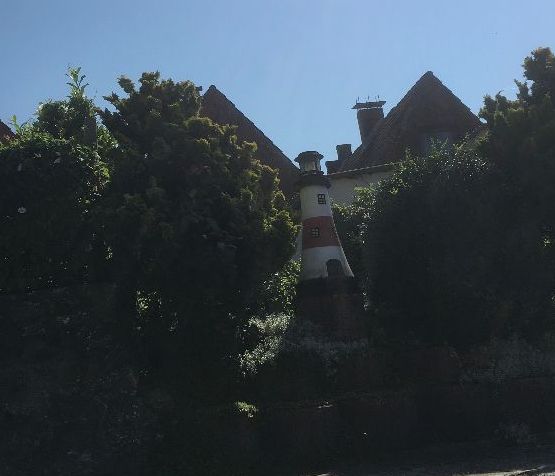 Kleines Haus versteckt zwischen Bäumen.