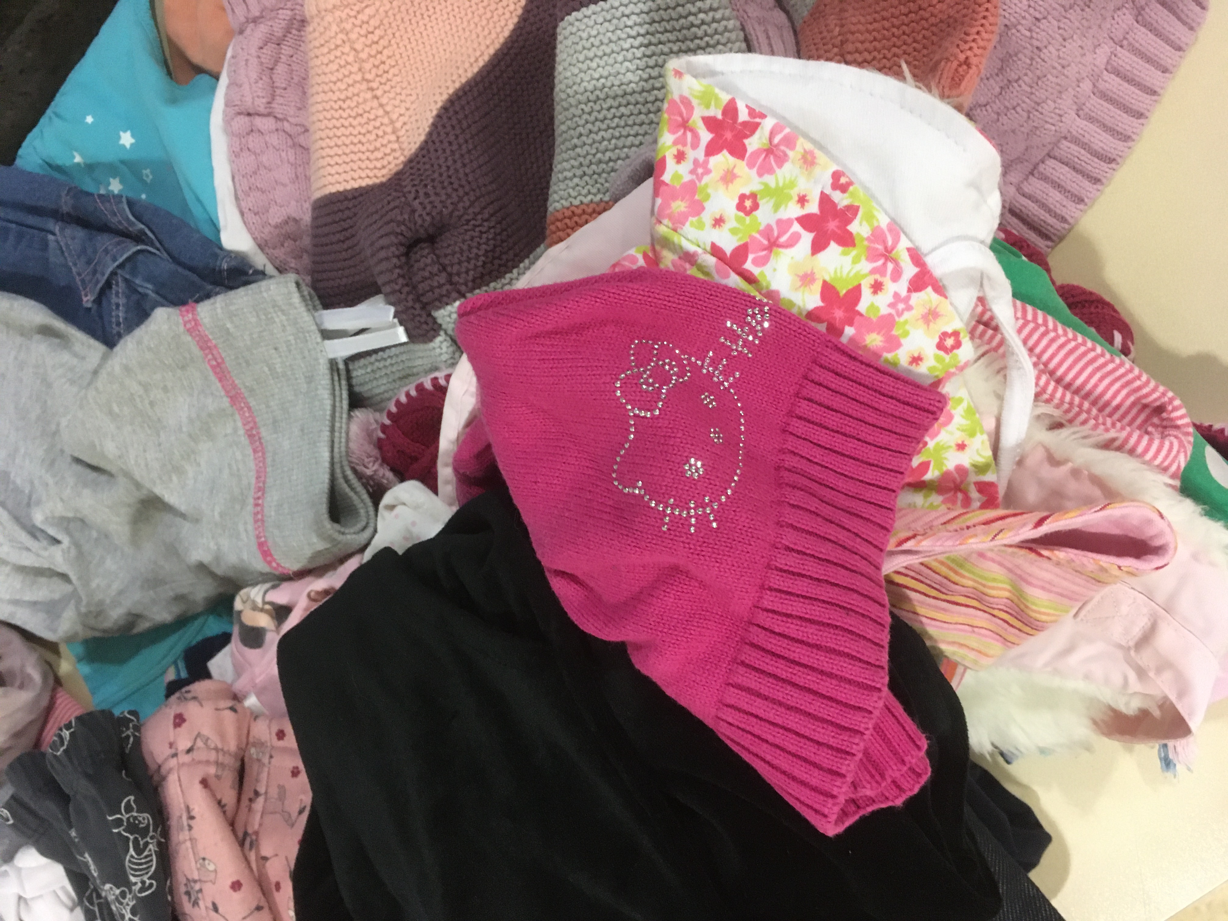 Kleiderhaufen mit pinker Mütze.