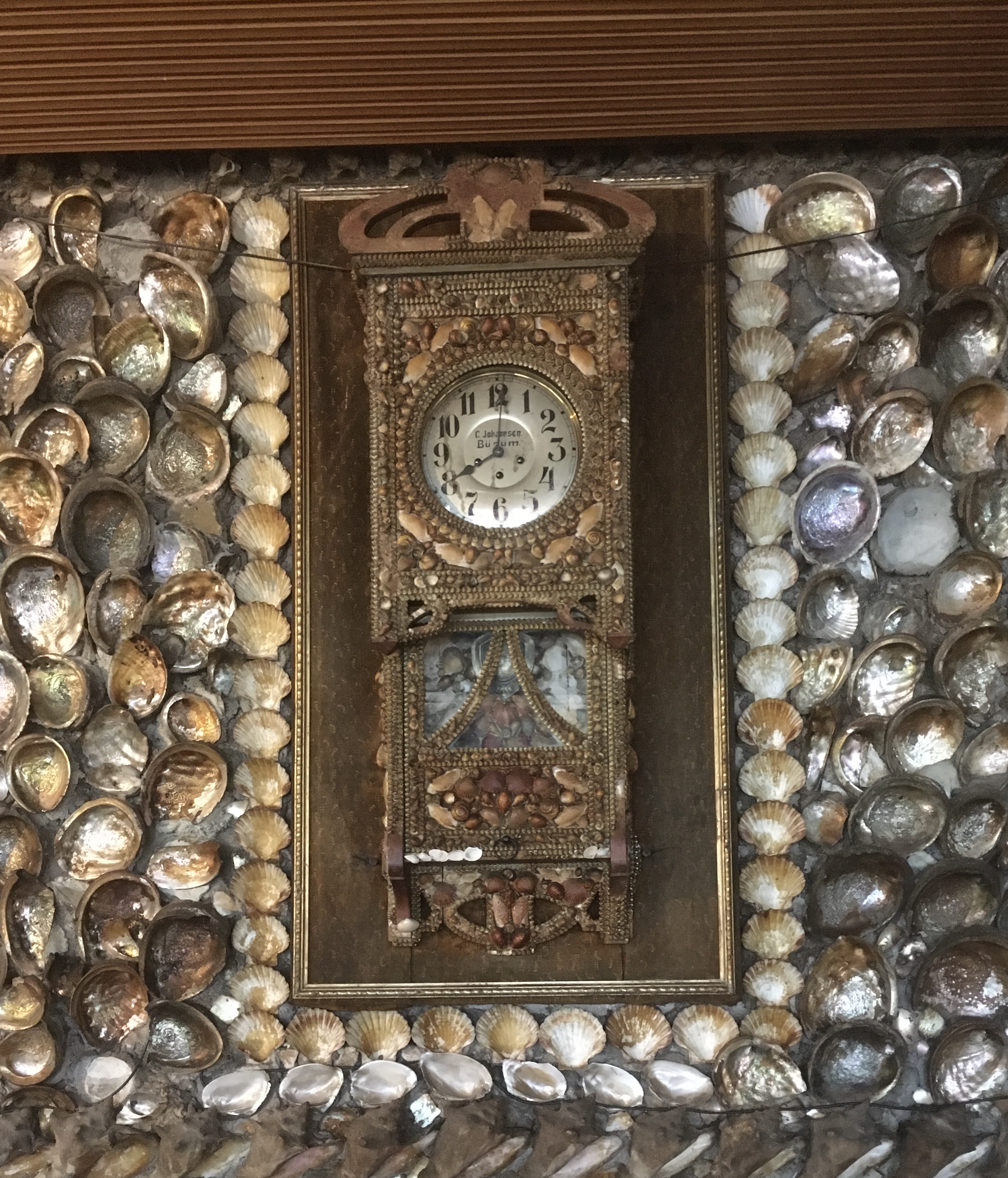 Ornate Uhr umrahmt von Muscheln.