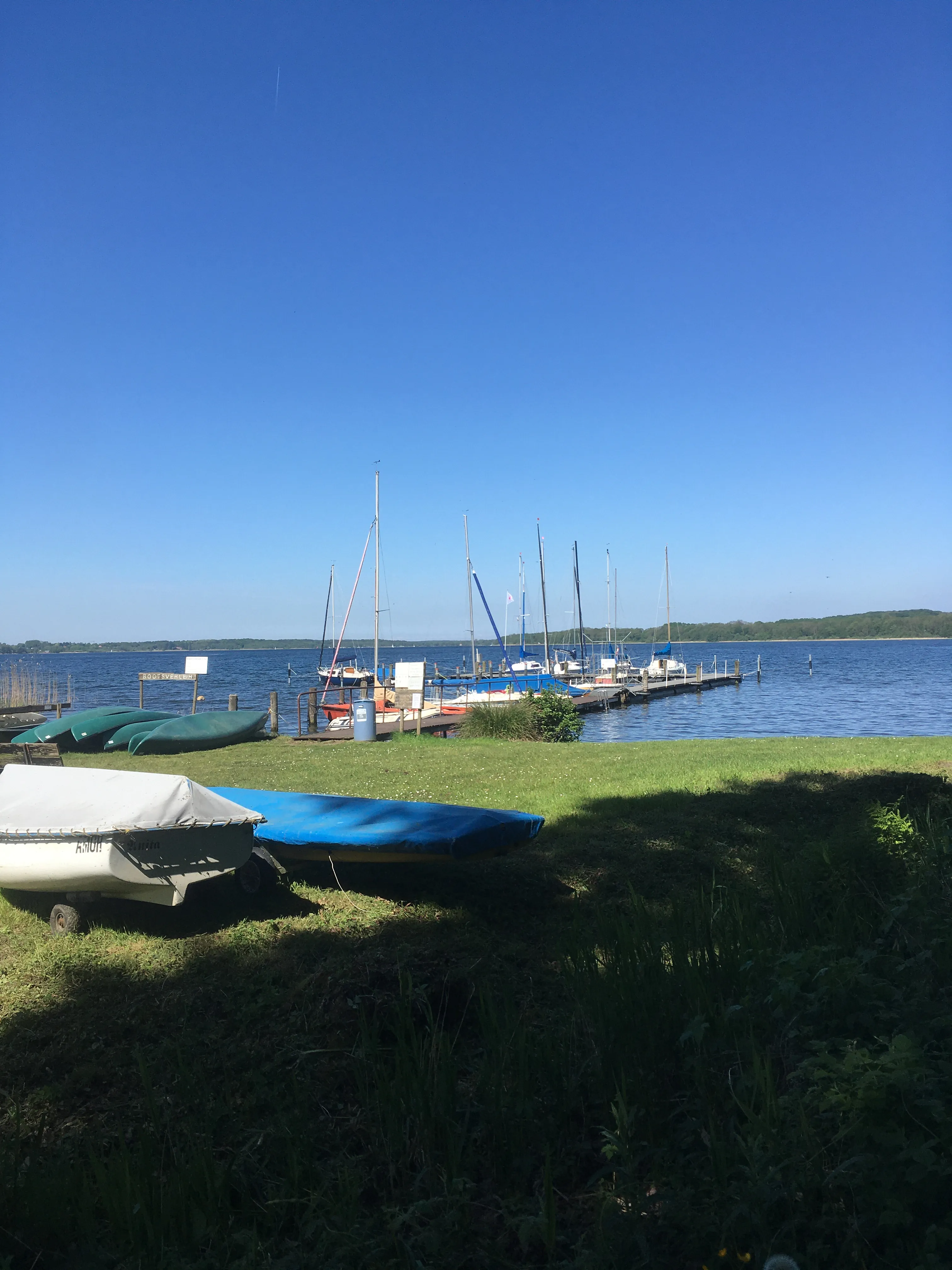 Boote am Steg in blauer Bucht.