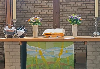 Altar mit Blumen und Bibel.